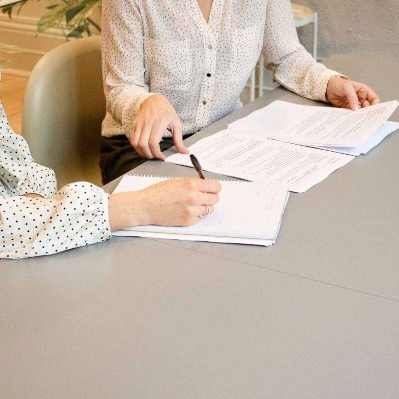 Woman signing papers on a table
